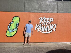 Man standing in front of Kaimuki mural