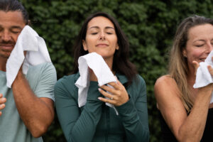A woman wiping her face with a wet washcloth