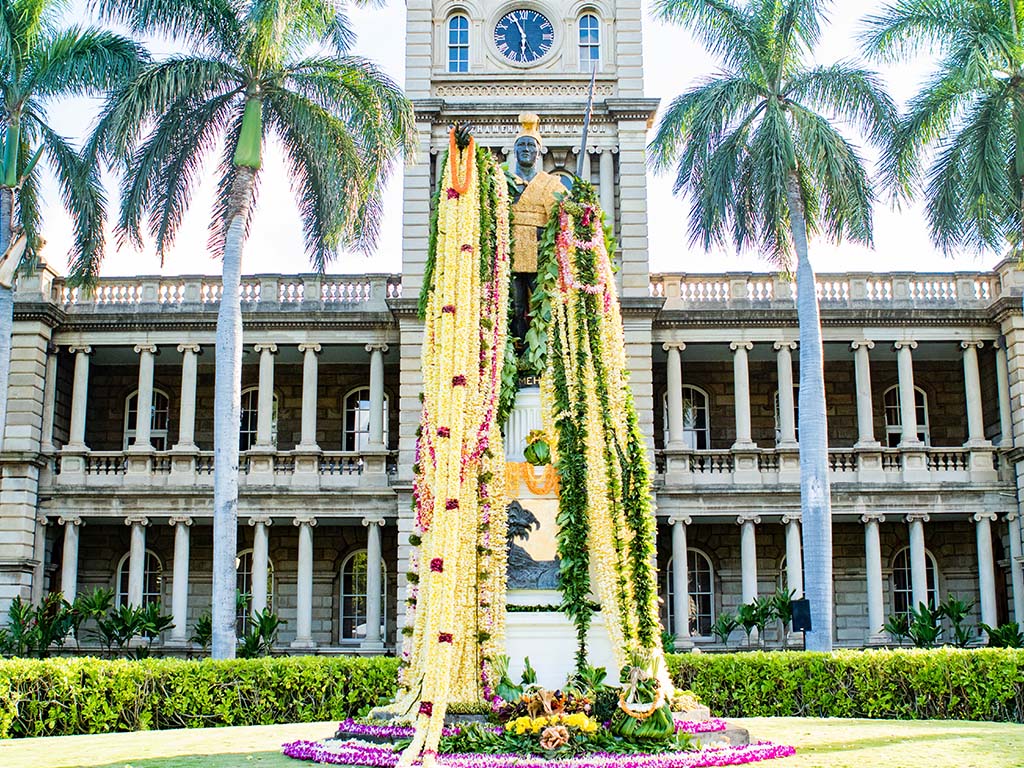statue with flower leis