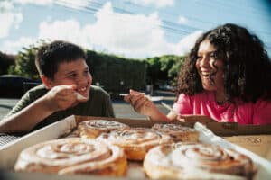 Two kids eating cinnamon rolls at Papiʻs Ohana in Maui, Hawaii.