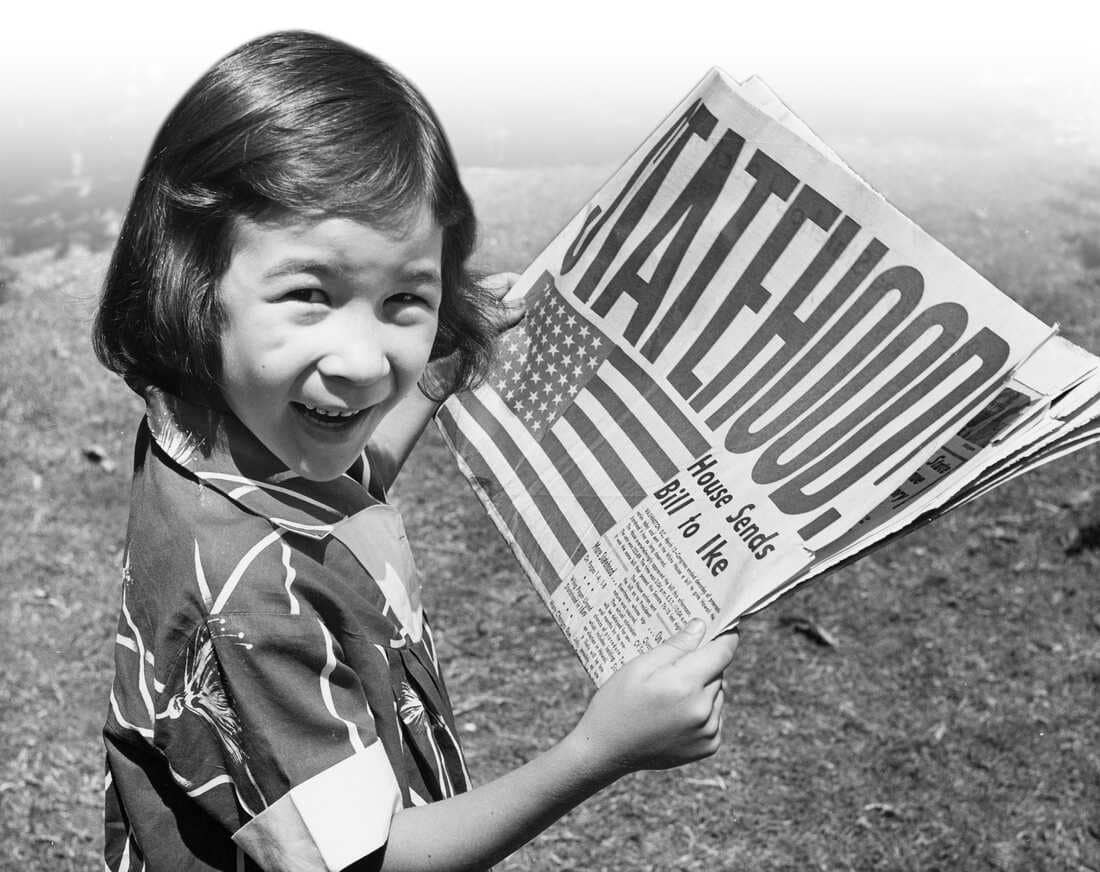 Girl holding Statehood newspaper in Hawaii
