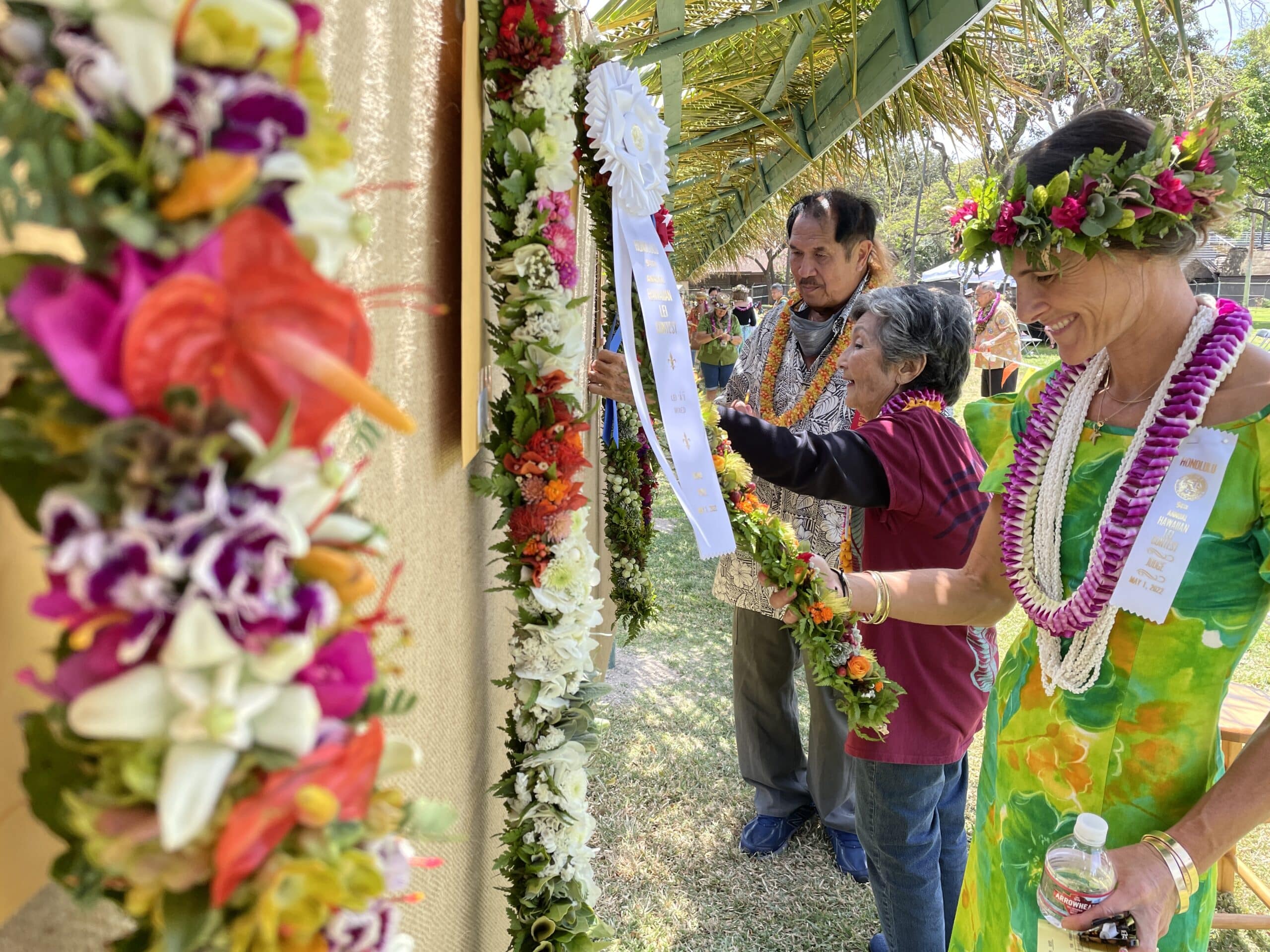 People looking at Hawaiian leis.